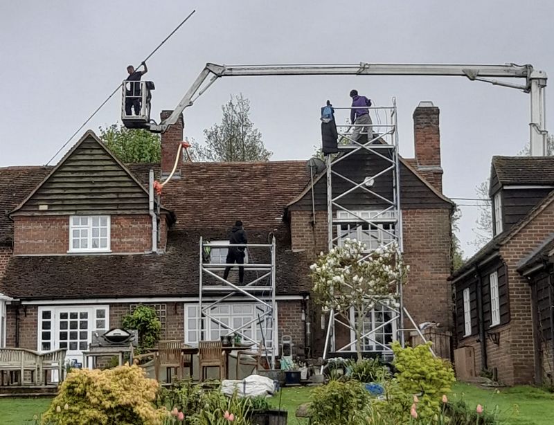 The Roof Moss Cleaners using cherry picker and scaffolding to clean roof safely and professionally in Reigate, Surrey